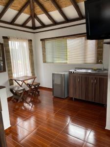 eine Küche mit Holzböden, einem TV und einem Tisch in der Unterkunft Apta villa de leyva in Villa de Leyva