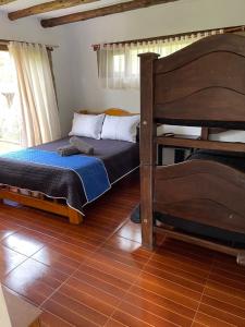 Schlafzimmer mit Etagenbett und Holzboden in der Unterkunft Apta villa de leyva in Villa de Leyva