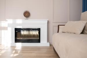 a room with a fireplace with a bed and a clock at Art Lite One RED APARTMENTS in Adler