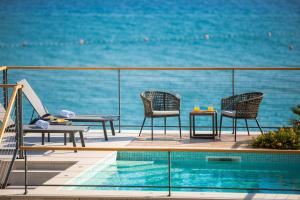 balcone con sedie e piscina con vista sull'oceano di Luxury beachfront VILLA FLORES heated outdoor, indoor pool, whirlpool, sauna a Duće