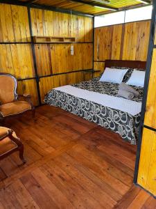 1 dormitorio con 1 cama y 1 silla en una habitación en Glamping en villa, en Villa de Leyva