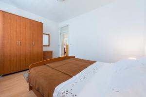 a bedroom with a bed and a wooden cabinet at Apartment Lena in Dubrovnik