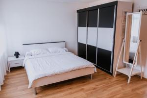 a bedroom with a large bed and a mirror at Studio Apartment Dzungla in Doboj