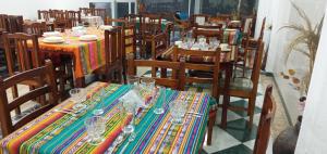 un restaurante con mesas y sillas con vasos. en Hostal Otavalos Inn, en Otavalo