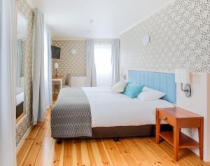 a bedroom with a large bed with a blue headboard at Fosshotel Eastfjords in Fáskrúðsfjörður
