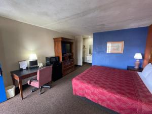 una camera d'albergo con letto e scrivania con computer di Knights Inn & Suites Emporia a Emporia