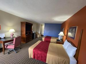una camera d'albergo con 2 letti e una scrivania di Knights Inn & Suites Emporia a Emporia