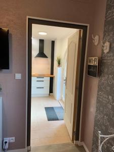 a hallway with a door open to a kitchen at Le nid de cigognes in Menchhoffen +21 photos