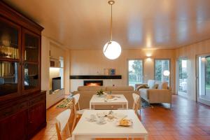 a living room with two tables and a couch at 70's wood house in Maia