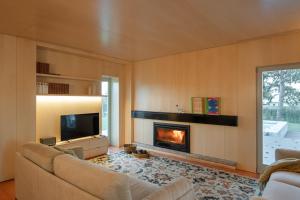 a living room with a fireplace and a tv at 70's wood house in Maia
