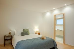 a bedroom with a large bed and a mirror at 70's wood house in Maia +46 photos