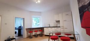una cocina con mesa de cristal y taburetes rojos en Modern living in a perfect location, en Essen