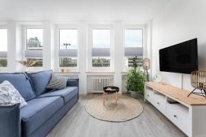 a living room with a blue couch and a tv at Himmelsstürmer Apartments by Stay Awesome in Kassel