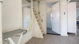 einen Flur mit einer Treppe und einer Tür zu einem Zimmer in der Unterkunft Alta Mar Studios in Scheveningen