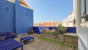 un balcón con una pared azul y un banco azul en Alta Mar Studios, en Scheveningen