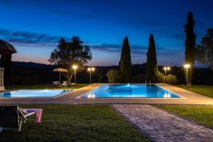 basen w ogrodzie w nocy w obiekcie Appartamento in casale con piscina Casa I Pavoni w mieście Chianni