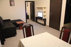 a living room with a couch and a table and a television at Hotel Feniks Požarevac in Požarevac