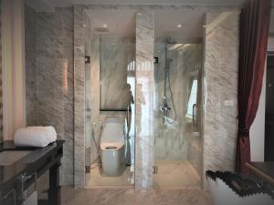y baño con ducha y aseo. en Nanta Glam CM Hotel & Residences en Chiang Mai