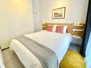 sypialnia z dużym białym łóżkiem z czerwonymi poduszkami w obiekcie MonKeys Apartments Los Viajantes w Sewilli