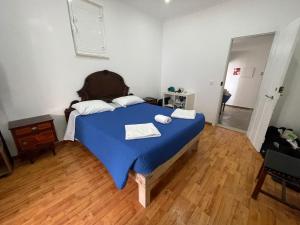 1 dormitorio con 1 cama azul y 2 toallas en Casa do Mestre, en Setúbal