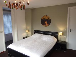 sypialnia z białym łóżkiem z 2 stolikami nocnymi i 2 lampami w obiekcie Meneer Pos w mieście Velp