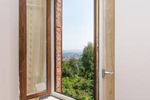 ein offenes Fenster mit Stadtblick in der Unterkunft Domus Gallina Charme e Relax in Bergamo