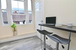 een bureau met een laptop en 2 stoelen bij Twin Bed Studio Near Train Station, Netflix, WiFi in Coventry