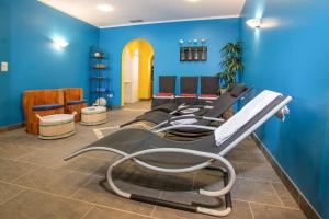 ein Wartezimmer mit blauen Wänden und leeren Stühlen in der Unterkunft Zillertal Appartements in Fügen