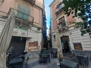 an outdoor cafe with tables and chairs in front of buildings at Borgo San Giovanni Rooms Catania in Catania