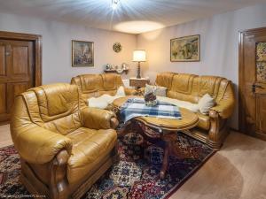 a living room with two leather couches and a table at Gościniec Pod Bukiem in Świeradów-Zdrój