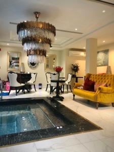 a living room with a yellow couch and a chandelier at Nanta Glam CM Hotel & Residences in Chiang Mai