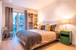 a bedroom with a bed and a large window at Funchal Center Apartment II in Funchal