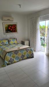 um quarto com uma cama com um quadro na parede em Linda Casa de Praia (Morada 3R's) Florianópolis/SC em Florianópolis