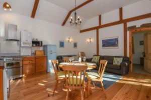 cocina y sala de estar con mesa y sillas en Bradbridge Barn en Newton Ferrers