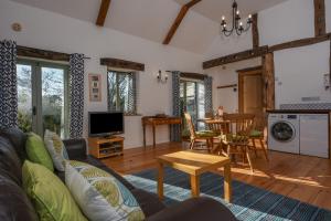ein Wohnzimmer mit einem Sofa und einem Tisch in der Unterkunft Bradbridge Barn in Newton Ferrers