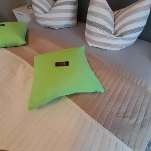 a green pillow sitting on top of a bed at Ferienwohnung Greschke in Prerow
