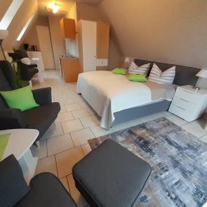 ein Schlafzimmer mit einem großen weißen Bett und einem Sofa in der Unterkunft Ferienwohnung Greschke in Prerow