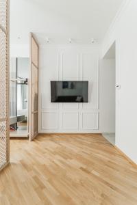 a living room with a television and a wooden floor at Zeus Design Apartments Schönbrunn in Vienna