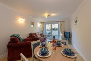 a dining room with a table and a living room at Waves Apartments in Newquay