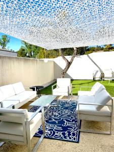 une terrasse avec des chaises blanches et un tapis bleu et blanc dans l'établissement COUP DE CŒUR - ILE DE RE - Maison 3 chambres, à Rivedoux-Plage