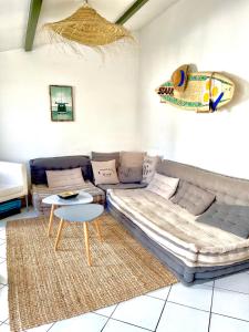 ein Wohnzimmer mit einem Sofa und einem Tisch in der Unterkunft COUP DE CŒUR - ILE DE RE - Maison 3 chambres in Rivedoux-Plage