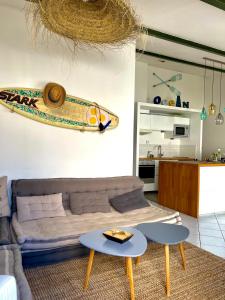 een woonkamer met een bank en een surfplank aan de muur bij COUP DE CŒUR - ILE DE RE - Maison 3 chambres in Rivedoux-Plage