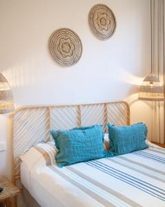 a bed with blue pillows in a room at Casa du Soleil in Madrid
