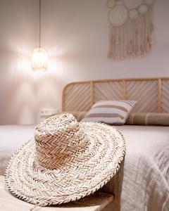 a straw hat sitting on top of a bed at Casa du Soleil in Madrid