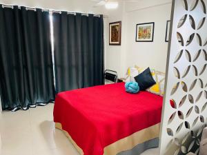 a bedroom with a red bed with a teddy bear on it at Loft london, estilo e praticidade no coração de Icarai in Niterói