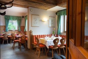 jadalnia ze stołami i krzesłami w restauracji w obiekcie Haus Patricia w mieście Kartitsch