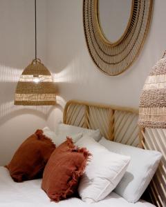 ein Bett mit zwei Kissen und einem Spiegel an der Wand in der Unterkunft Casa du Soleil in Madrid