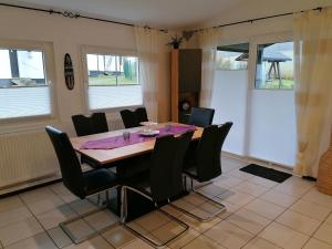 a dining room with a table and black chairs at Ferienhaus Bella in Willingen