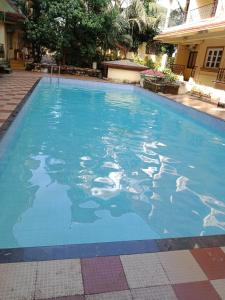 une grande piscine d'eau bleue dans l'établissement Utopia Holiday Candolim, à Candolim