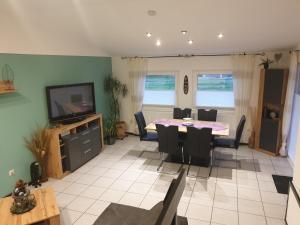 a living room with a dining room table and a television at Ferienhaus Bella in Willingen